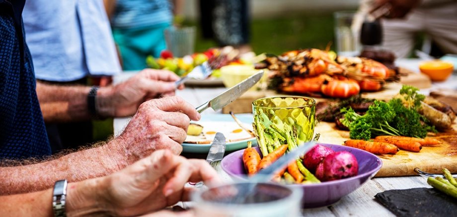Menschen, die gemeinsam am Tisch sitzen und essen.