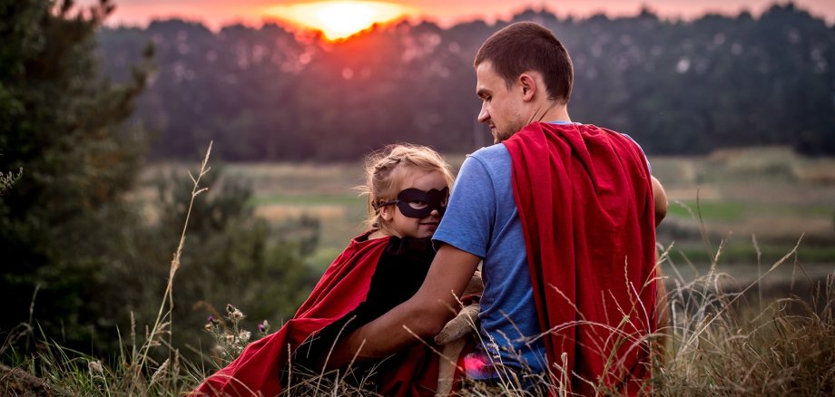 little girl with dad dressed in super heroes, happy loving family