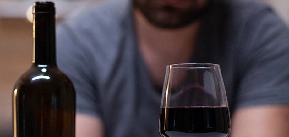 Close up of glass with wine for lonely man in kitchen Close up of glass with wine for lonely man in kitchen