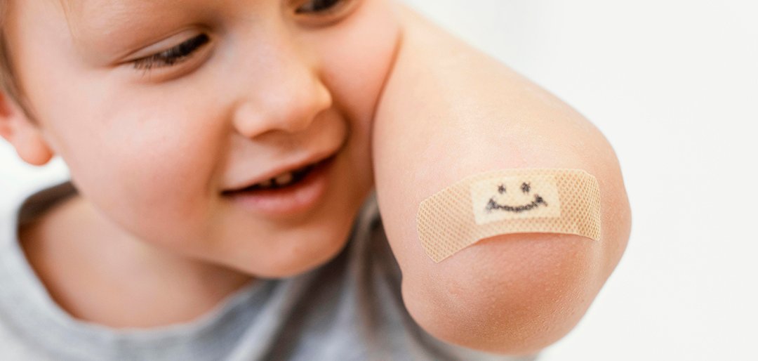 Kleinkind sitzt mit Kaffeetasse am Tisch.