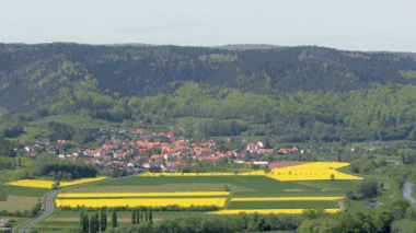 Luftbild von Braach mit leuchtend-gelben Rapsfeldern im Vordergrund.